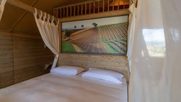 A bedroom with a wooden headboard, a bed with white linens, and a painting of a landscape above the bed.
