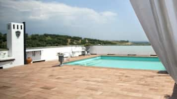 Una piscina al aire libre de temporada, sillones reclinables de piscina