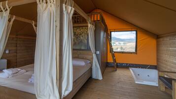 Una habitación con cama de madera, ventana con vistas, bañera y una escalera.