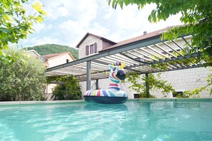 Une piscine avec un zèbre gonflable multicolore servant de bouée.