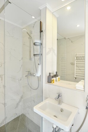 Chambre Deluxe double ou avec lits jumeaux | Salle de bain | Douche, articles de toilette (gratuits), séchoir à cheveux, peignoirs
