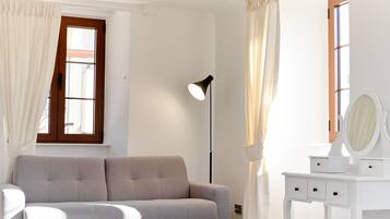 Chambre Deluxe Double ou avec lits jumeaux | Coin séjour | Télévision à écran plat, livres