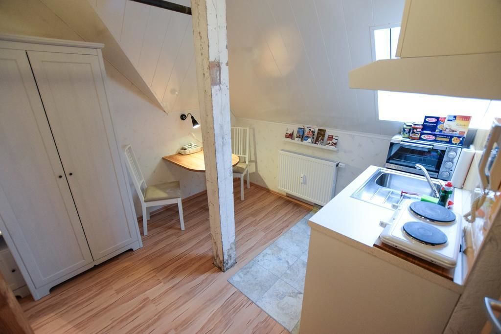 A compact kitchen with a built-in oven, a sink, and a small dining area.