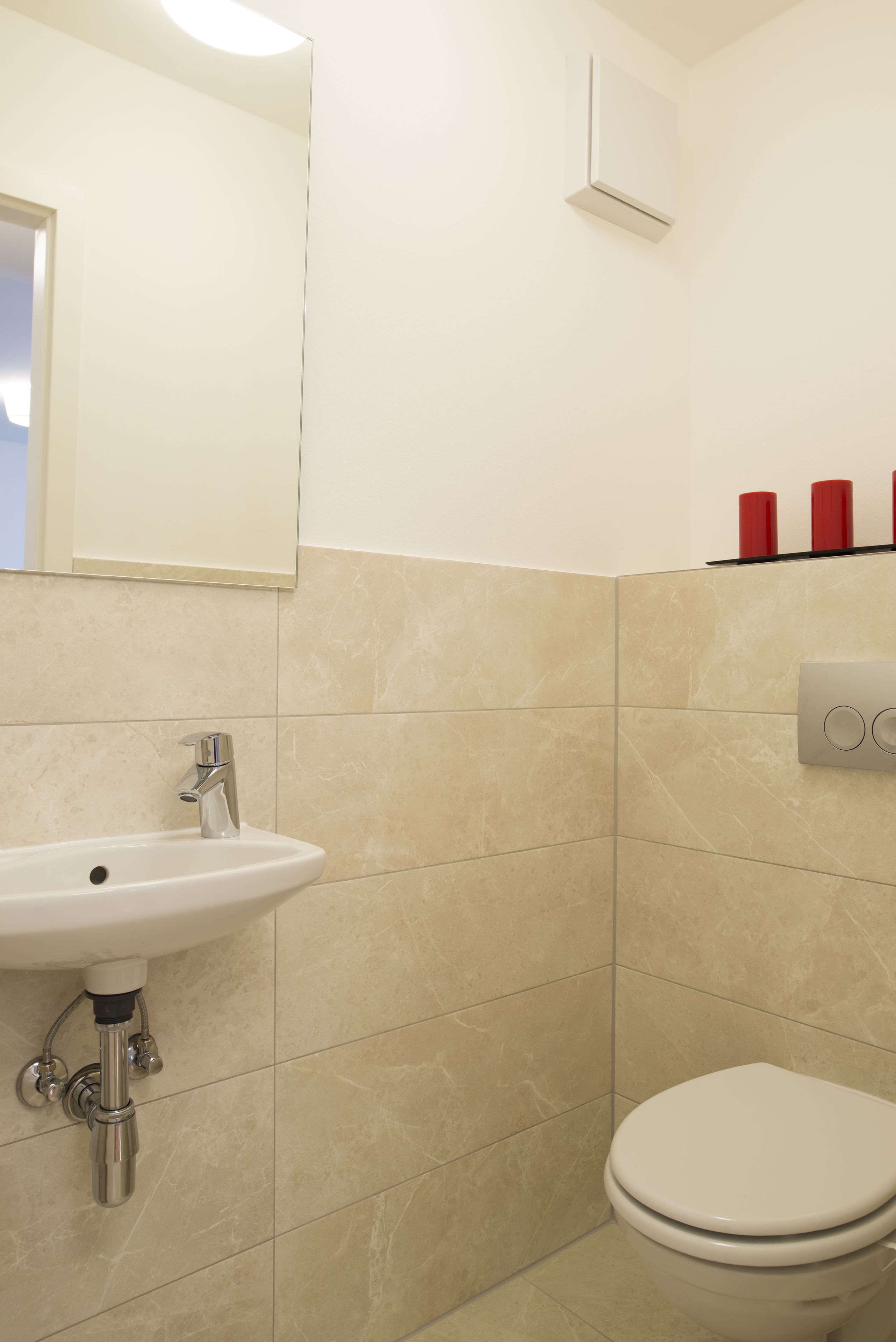 Ein Badezimmer mit Waschbecken, Toilette und Spiegel.
