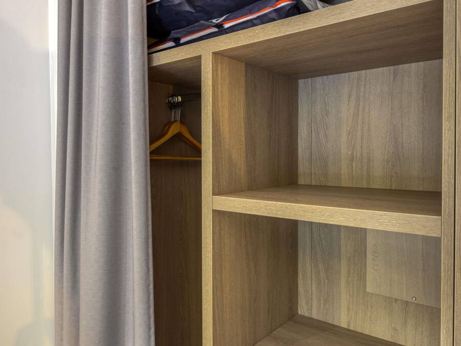 Une armoire en bois avec deux étagères et un espace pour suspendre les vêtements.