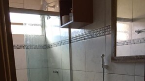 Un baño con inodoro, lavabo y zona de ducha.