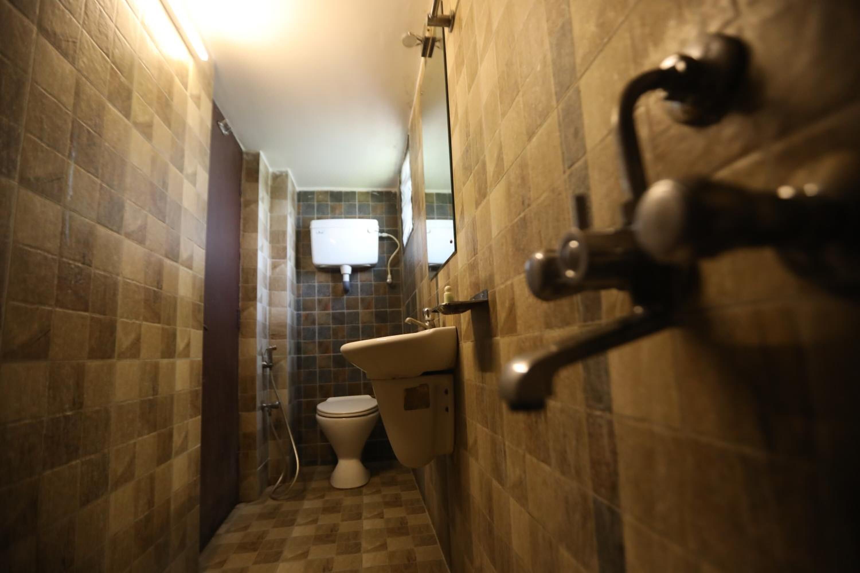 Un baño pequeño con inodoro, lavamanos y ducha.