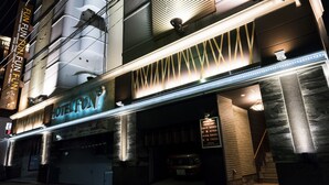 A hotel facade with a neon sign, a price list, and a staircase leading to the entrance. - Fun Fun Fun Kingdom - Adults Only (Yokohama)