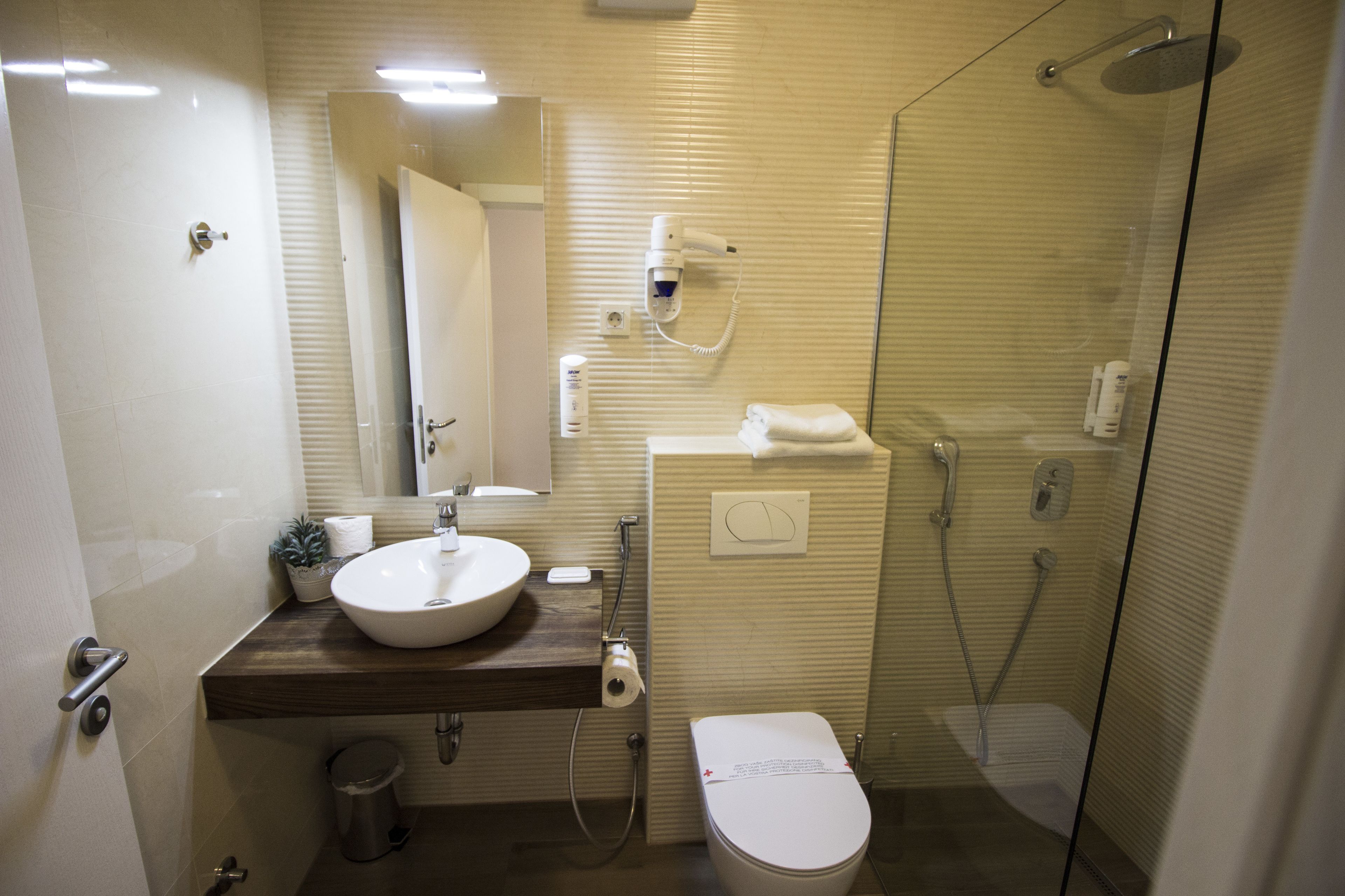A modern bathroom with a sink, toilet, and shower.