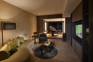 Una sala de estar moderna con sofá, mesa de centro y televisor.
