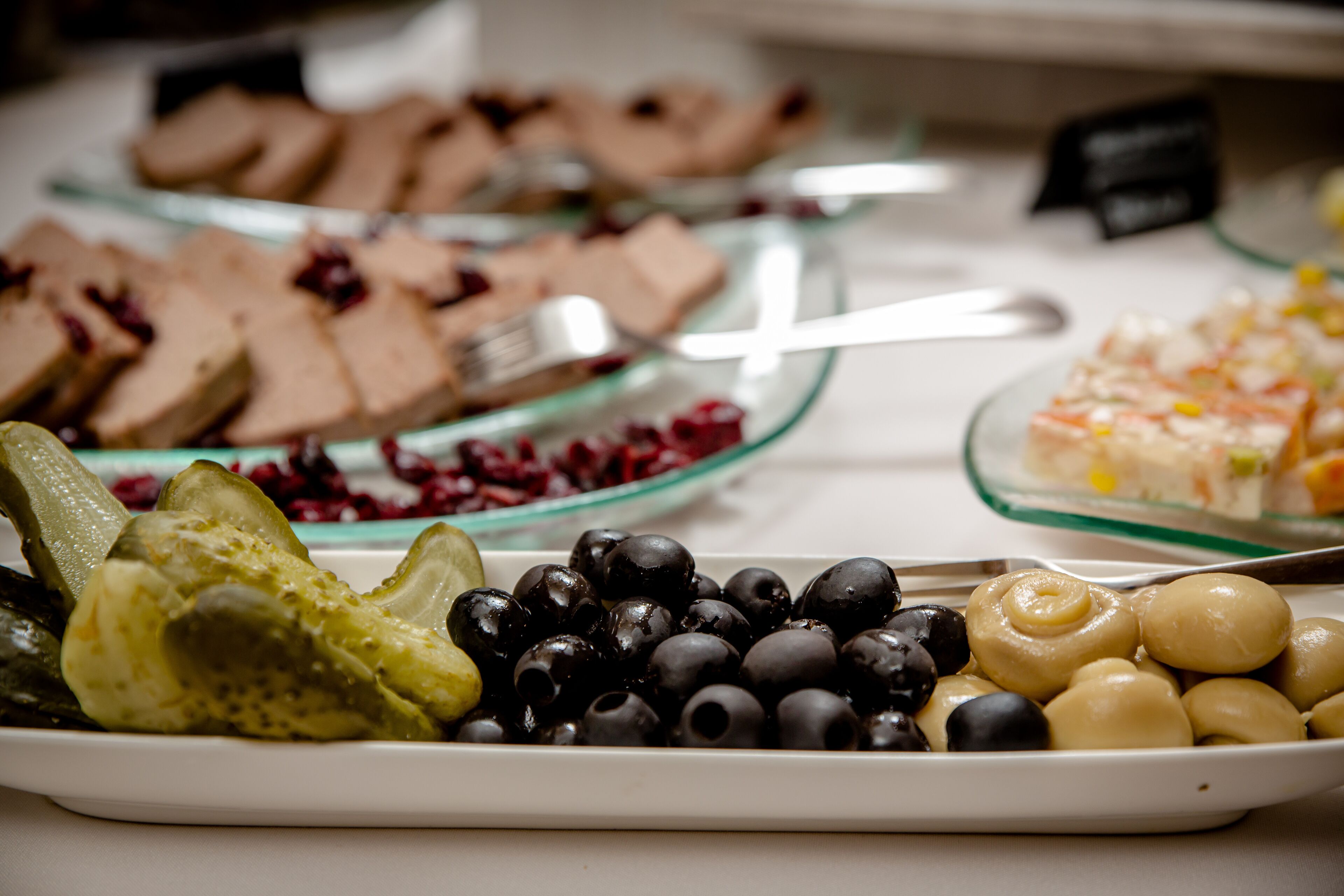Buffet amb diversos plats, incloent fruita, olives i una selecció de postres.
