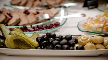 Buffet amb diversos plats, incloent fruita, olives i una selecció de postres.