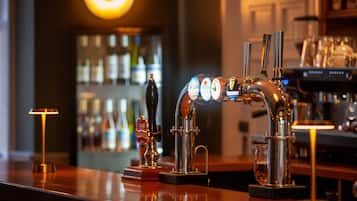 Un bar avec plusieurs robinets, un robinet à bière et un verre de bière posé sur le comptoir.