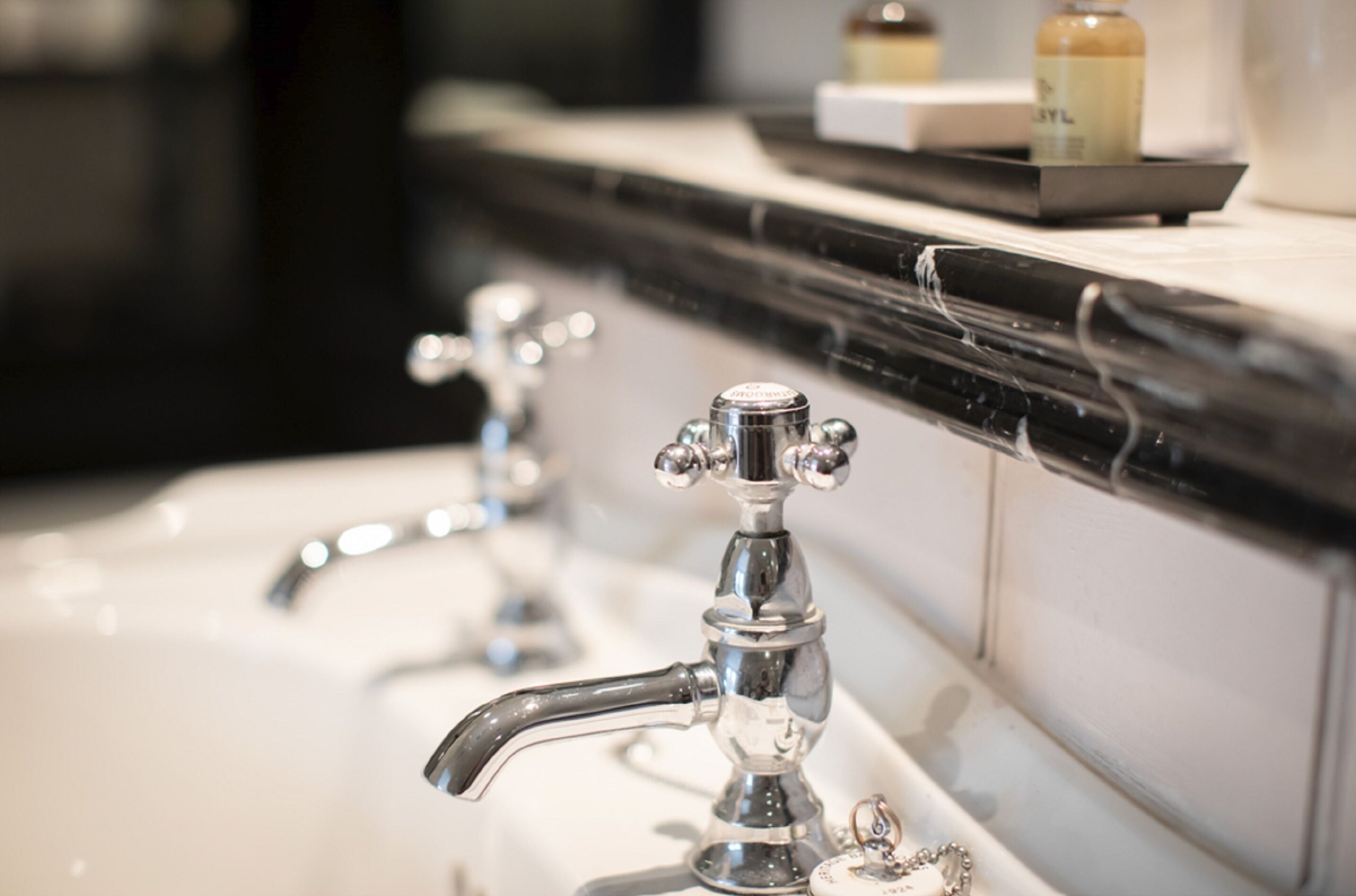 A bathroom with a black countertop and a white sink.