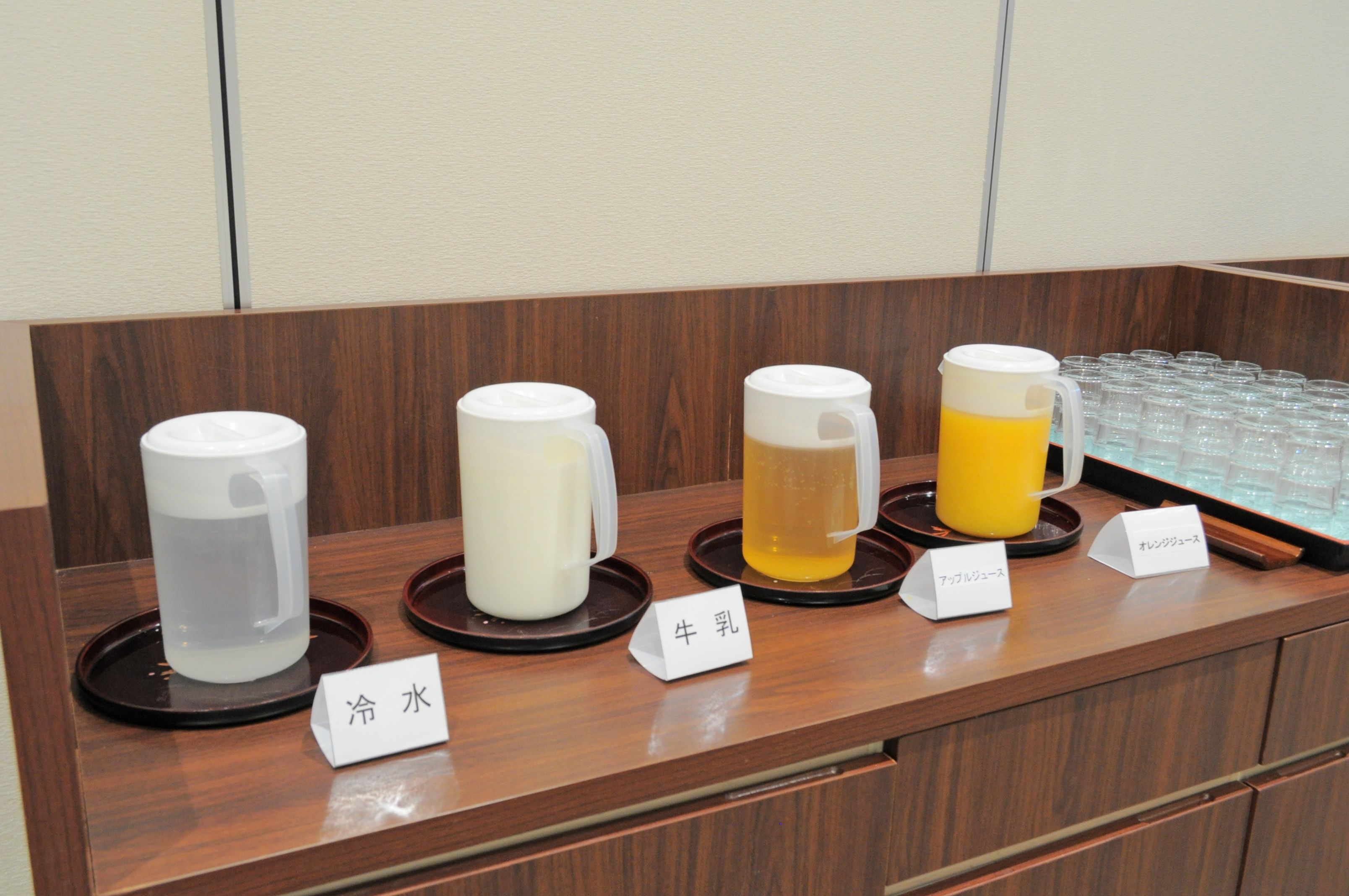 A beverage station with labeled dispensers for cold water, milk, and two types of tea.