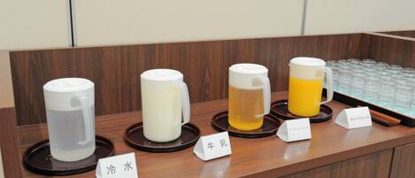 A beverage station with labeled dispensers for cold water, milk, and two types of tea.