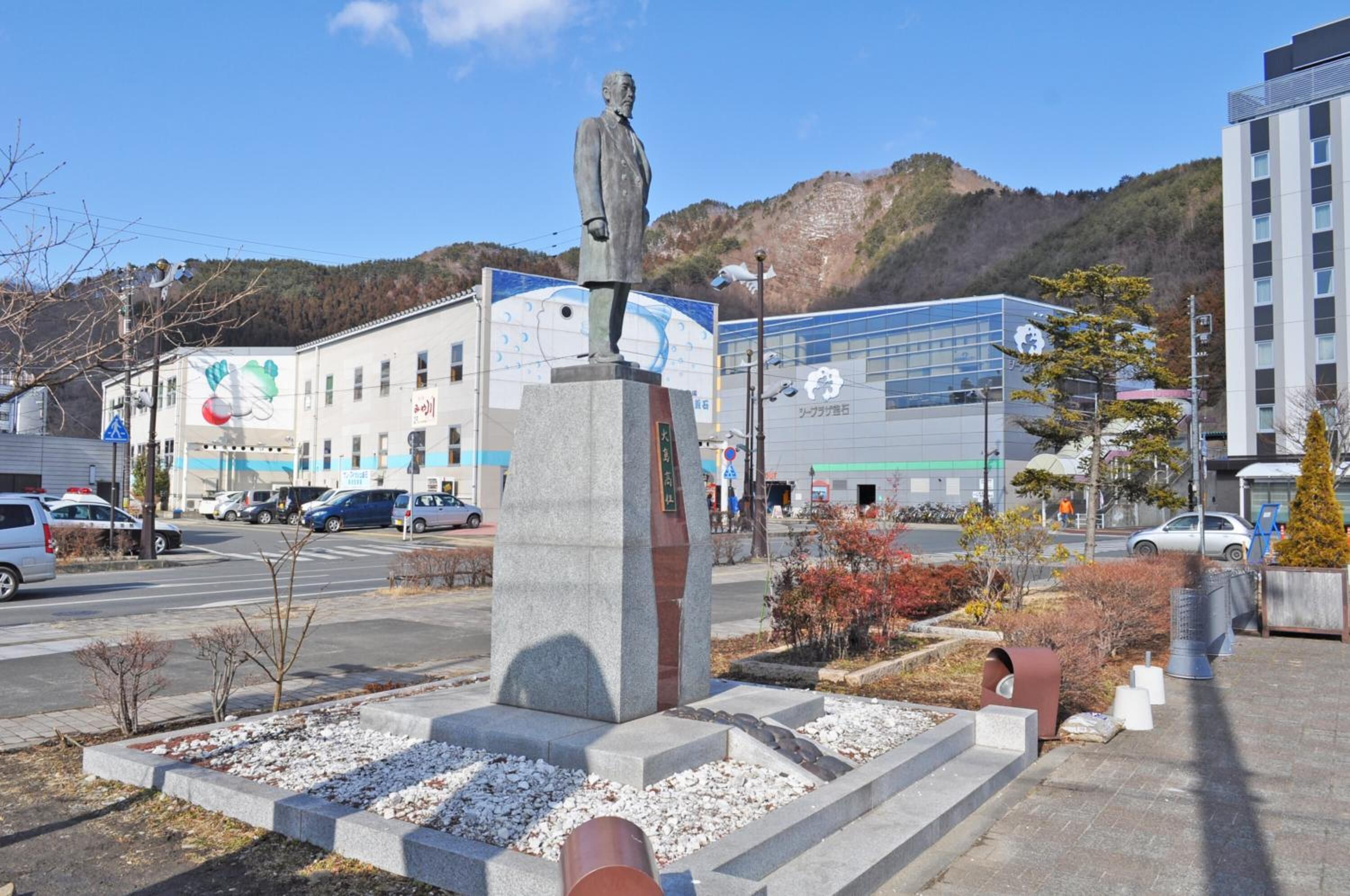 A statue in a public square with a building in the background.