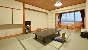 A traditional Japanese-style room with tatami flooring, a low table, and sliding doors. - Rikuchu Kaigan Grand Hotel (Kamaishi)