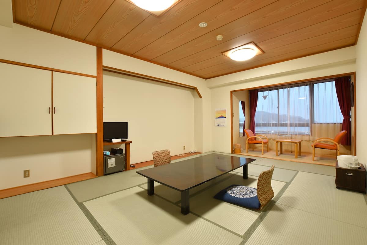 A traditional Japanese-style room with tatami flooring, a low table, and sliding doors.