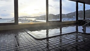 An indoor swimming pool with large windows overlooking a coastal area. - Rikuchu Kaigan Grand Hotel (Kamaishi)
