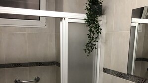 A bathroom with a shower, toilet, and sink. - Pensión Arias (Bilbao)