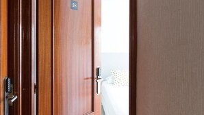 A hotel room door with a digital lock and a number sign. - Pensión Arias (Bilbao)