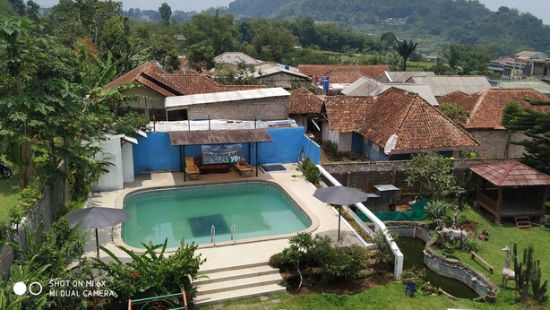 A residential area with a swimming pool, a small outdoor seating area, and a variety of houses with different roof styles. - Villa Pribadi Beunying 35 pax (Cipanas)