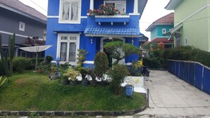 A two-story house with a blue facade, white windows, and a tiled roof. - Villa Abdi Cipanas with Swimming Pool (Cipanas)