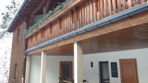 A wooden building with a balcony, a door, and a bench. - Gasthof&Pension Brettmühle (Koenigswalde)