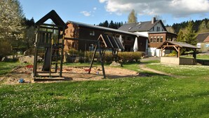 A wooden house with a large porch and a swing set in the yard. - Gasthof&Pension Brettmühle (Koenigswalde)