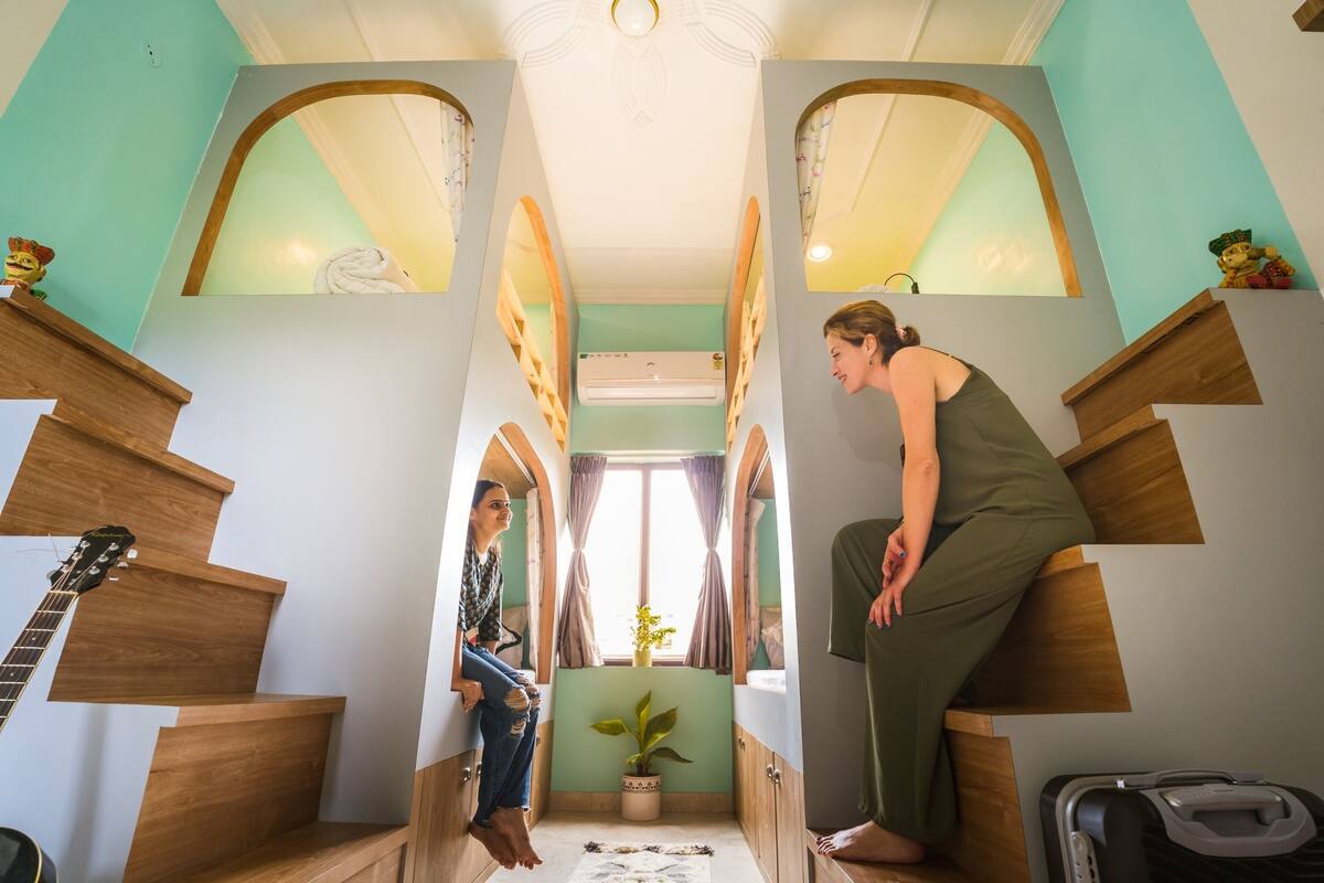 A narrow, multi-level room with wooden staircases and arched doorways.