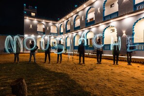 Un patio con un edificio que tiene arcos y un cielo nocturno.