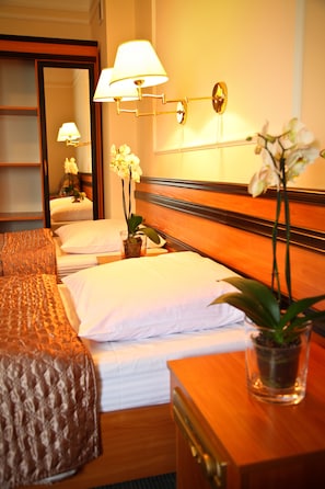 A hotel room with a wooden bed, white bedding, a nightstand with a lamp, and a potted orchid. - Wzgórze Toskanii (Tarnowo Podgorne)