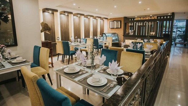 A restaurant with tables set for dining, a bar area, and a counter with a menu. - Panorama Summit Hotel (Davao)