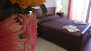 A hotel room with a bed, a nightstand, and a window with curtains. - Terrazze sul Tirreno (Lascari)