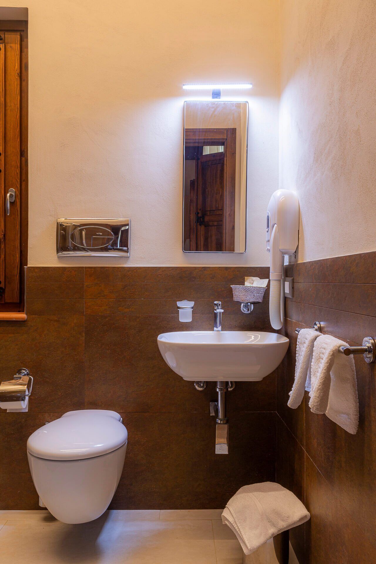 Un baño con inodoro, lavabo y toallero.