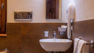Un baño con inodoro, lavabo y toallero.