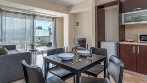 A modern apartment with a dining area, kitchen, and balcony. - Elvita Apartments 2 (Athens)