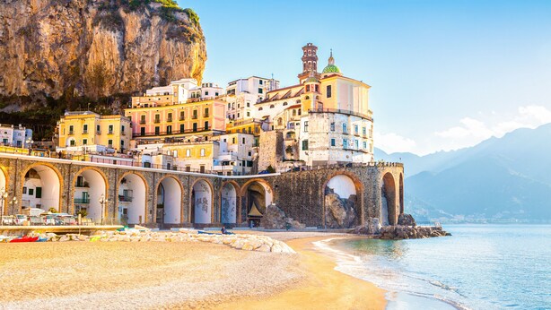 A coastal town with a prominent cliffside building featuring multiple balconies and a tower. - Donna Lena Relais (Naples)
