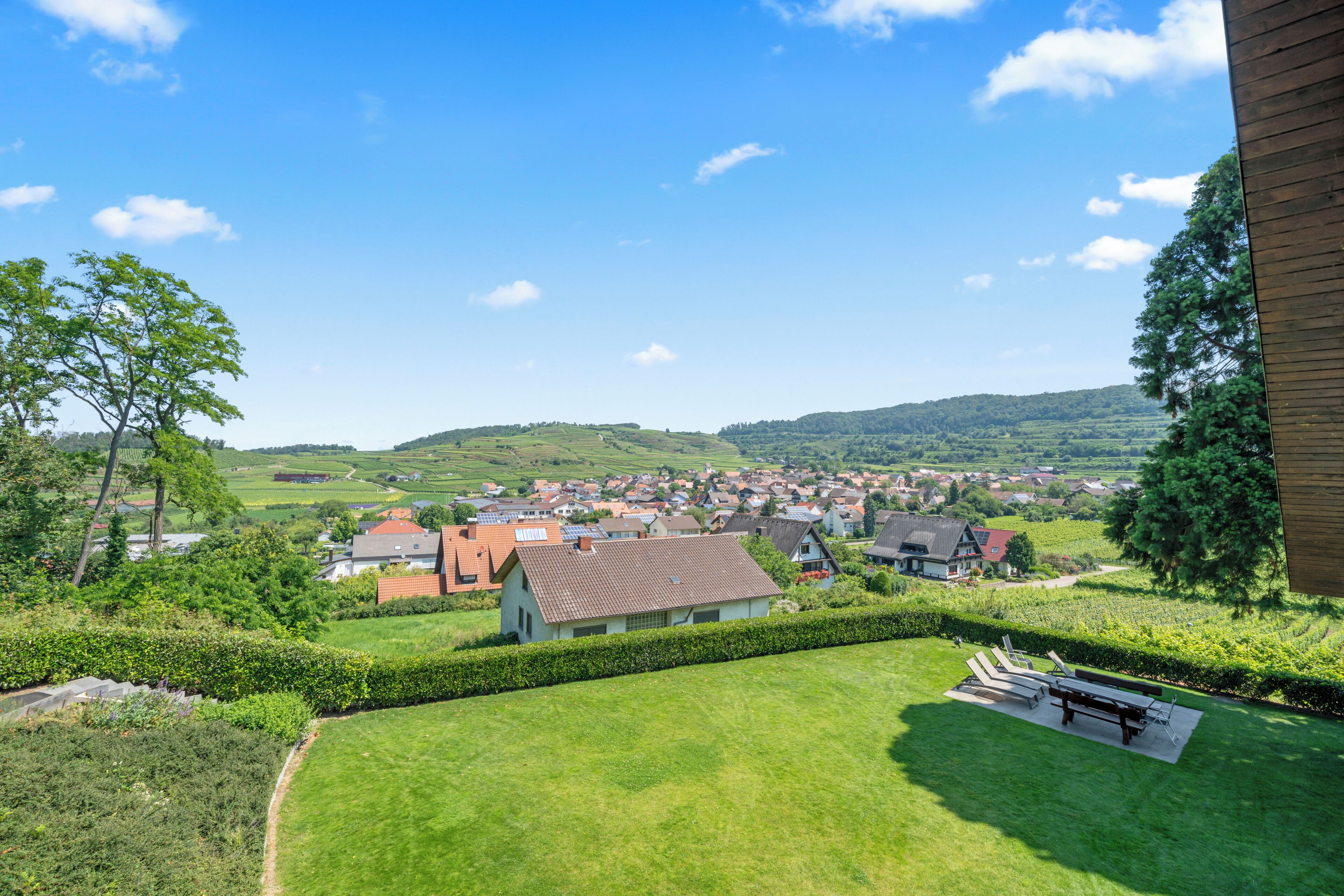 A residential area with houses, a well-maintained lawn, and a clear view of the surrounding landscape.