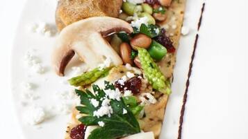 A dish with various toppings and a chocolate drizzle on a white plate.