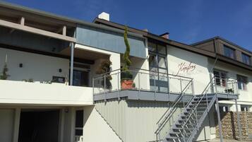 A modern building with a staircase leading to a balcony, a garage, and a sign that reads "King's Steinbuck."