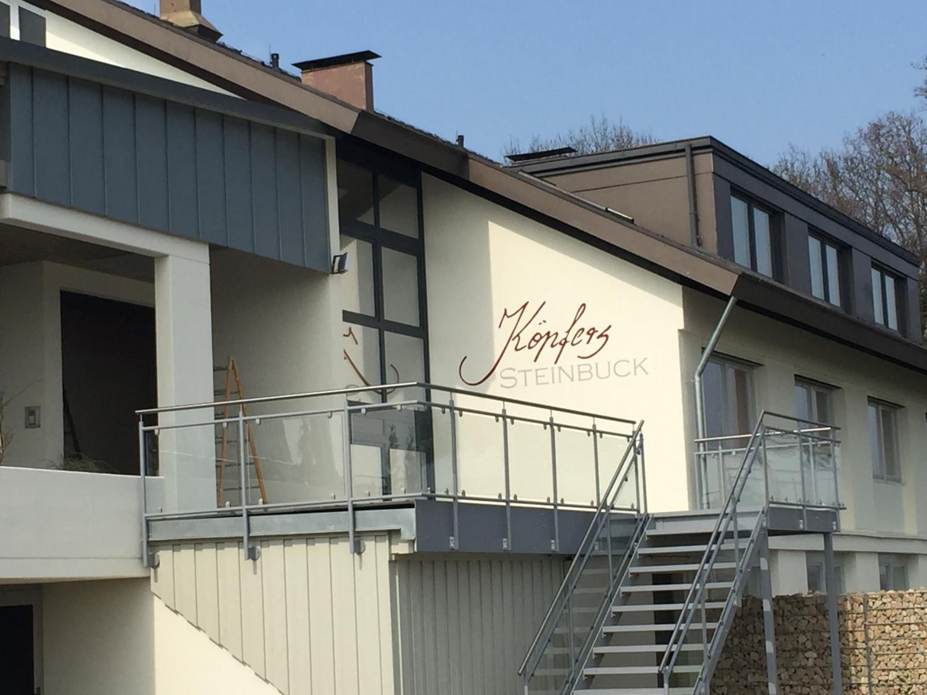 A modern building with a sign reading "Königs Steinbuck".
