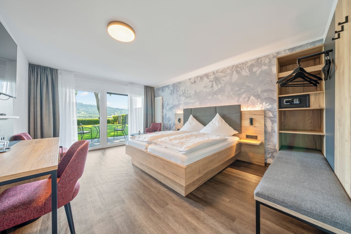 Een moderne hotelkamer met een groot bed, een eettafel en uitzicht op de omgeving.