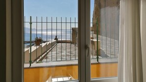 Un balcón con vista al mar y a las montañas.