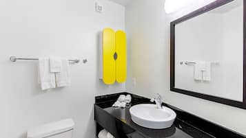 Een douche, handdoeken, zeep, toiletpapier