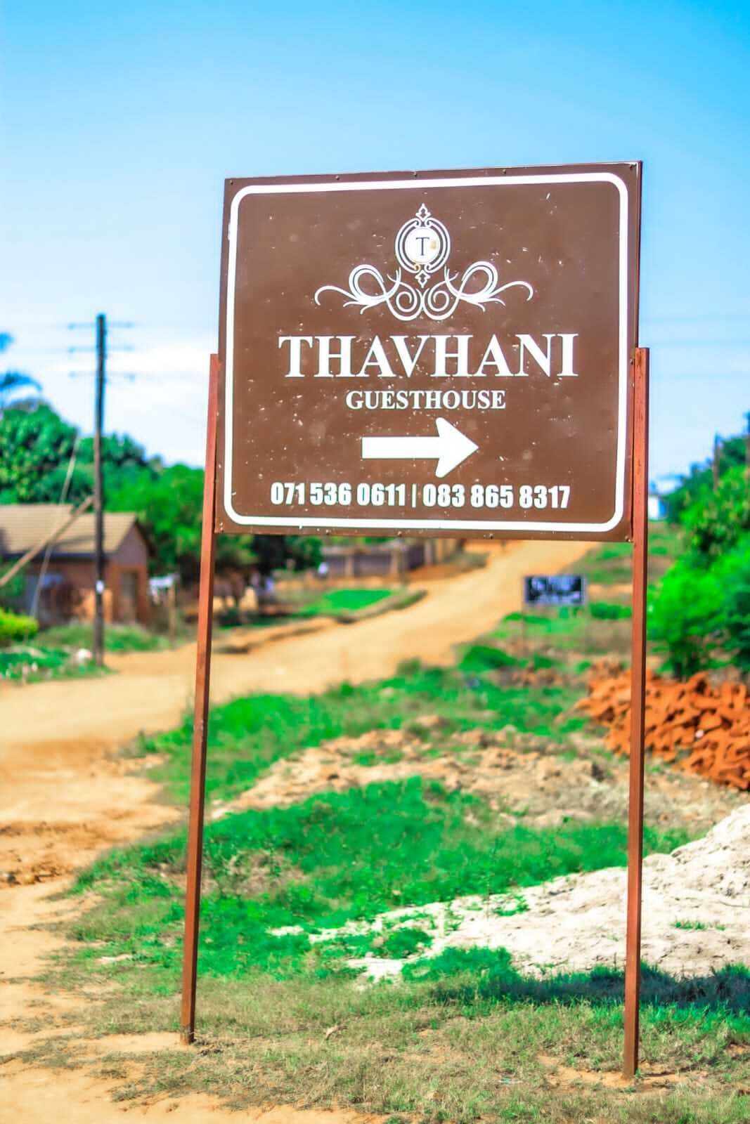 A sign for Thavhani Guesthouse with contact numbers.