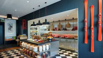 Una cocina moderna con piso de cuadros, una isla central con alimentos y esquíes rojos en la pared.