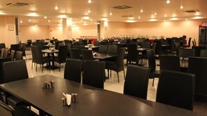 Un amplio comedor con numerosas mesas y sillas, dispuestas en filas.