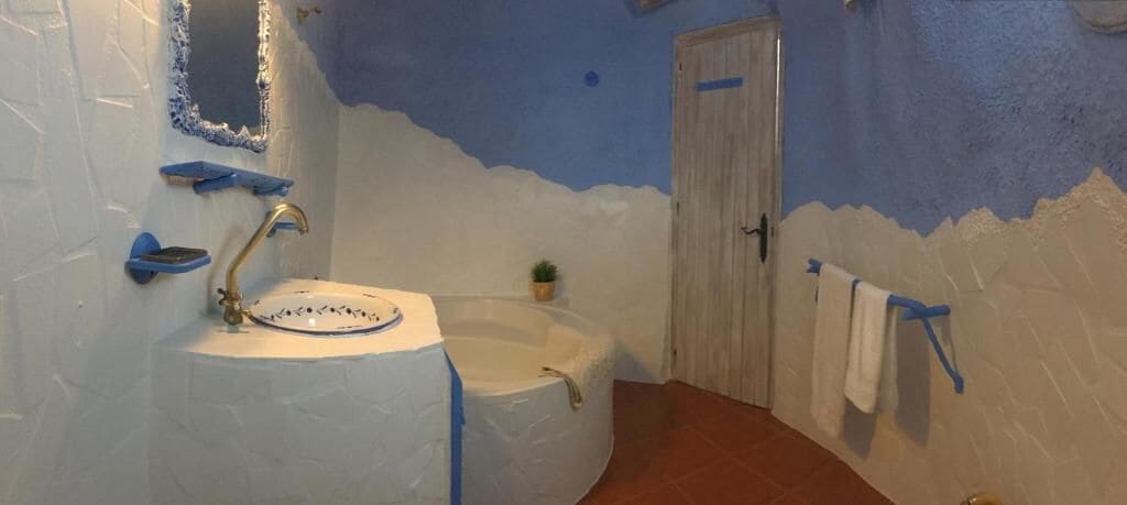 Een badkamer met een wastafel, bad en een deur.